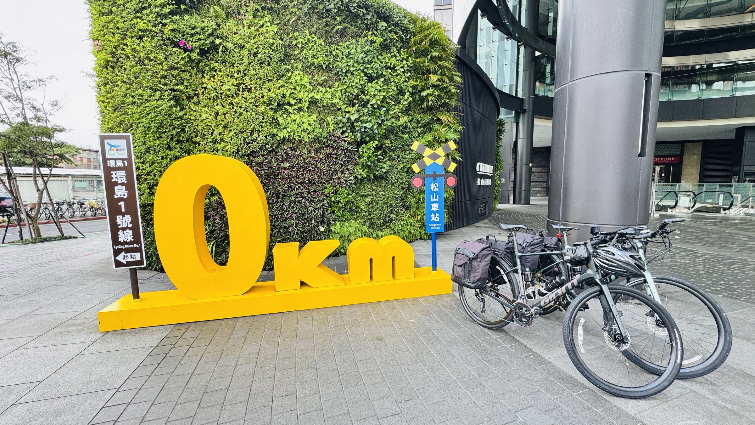 Both Giant FastRoad SLR 2 bicycles fully loaded and ready to go at the 0km marker in Taipei